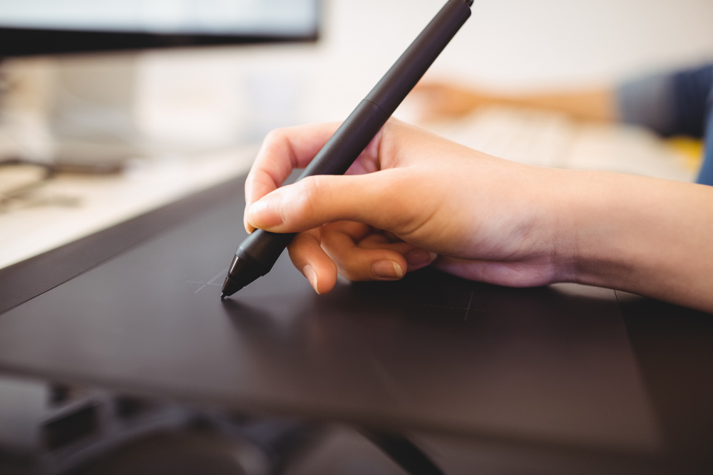 Cropped image of female digitizer using graphics tablet at creative office